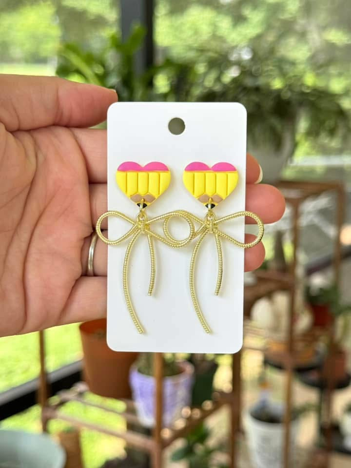 Pencil and golden bow dangling earrings